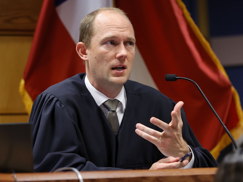 caption: Fulton County Superior Judge Scott McAfee presides in court during a hearing in the Georgia election interference case.