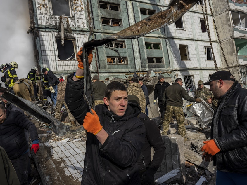 caption: Following a Russian attack, first responders remove rubble at a residential building in Uman, central Ukraine, Friday, April 28, 2023.
