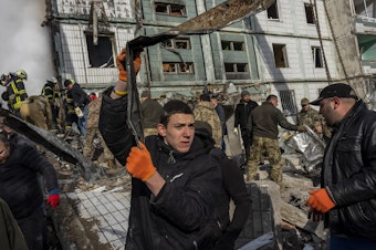 caption: Following a Russian attack, first responders remove rubble at a residential building in Uman, central Ukraine, Friday, April 28, 2023.