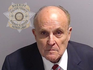 caption: In this handout provided by the Fulton County Sheriff's Office, Rudy Giuliani, former personal lawyer for former President Donald Trump, poses for his booking photo on August in Atlanta.