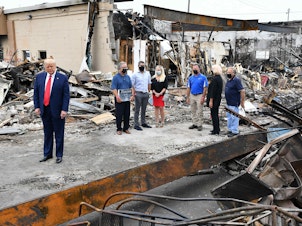 caption: US President Donald Trump tours an area affected by civil unrest in Kenosha, Wisconsin on September 1, 2020.