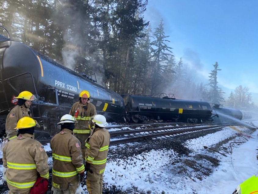 caption: Fire crews respond to the scene of a derailed train in the city of Custer, WA in Whatcom County on Tuesday, December 22, 2020. A BNSF spokesperson said seven train cars derailed and two caught fire.
