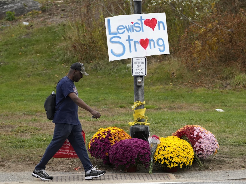 caption: A man walks by flowers and a sign of support for the community, Oct. 28, 2023, in the wake of the mass shootings that occurred on in Lewiston, Maine. The Maine Legislature on Thursday approved sweeping gun safety legislation nearly six months after the deadliest shooting in state history.