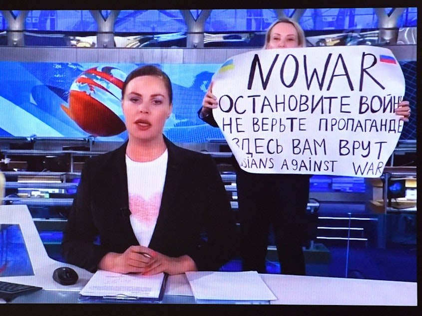 caption: A dissenting Channel One employee interrupted Russia's most-watched evening news broadcast, holding a poster reading as "No War" and "Russians for peace" and condemning Moscow's military action in Ukraine.