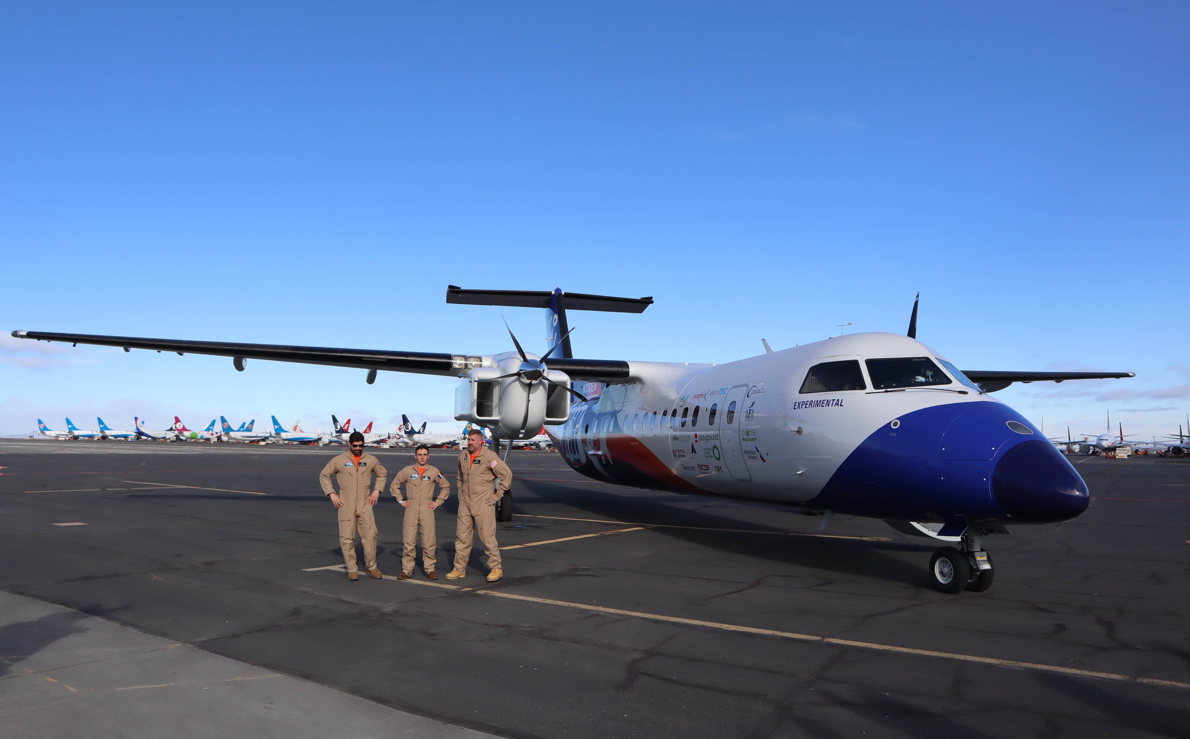 caption: The Universal Hydrogen flight test crew posed for pictures after a successful first flight of the company's hydrogen-electric Dash 8 airliner on March 2, 2023.