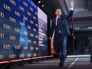 caption: Republican presidential candidate Florida Gov. Ron DeSantis waves as he leaves the stage after speaking to the Christians United For Israel (CUFI) Summit 2023 in Arlington, Va., on Monday.
