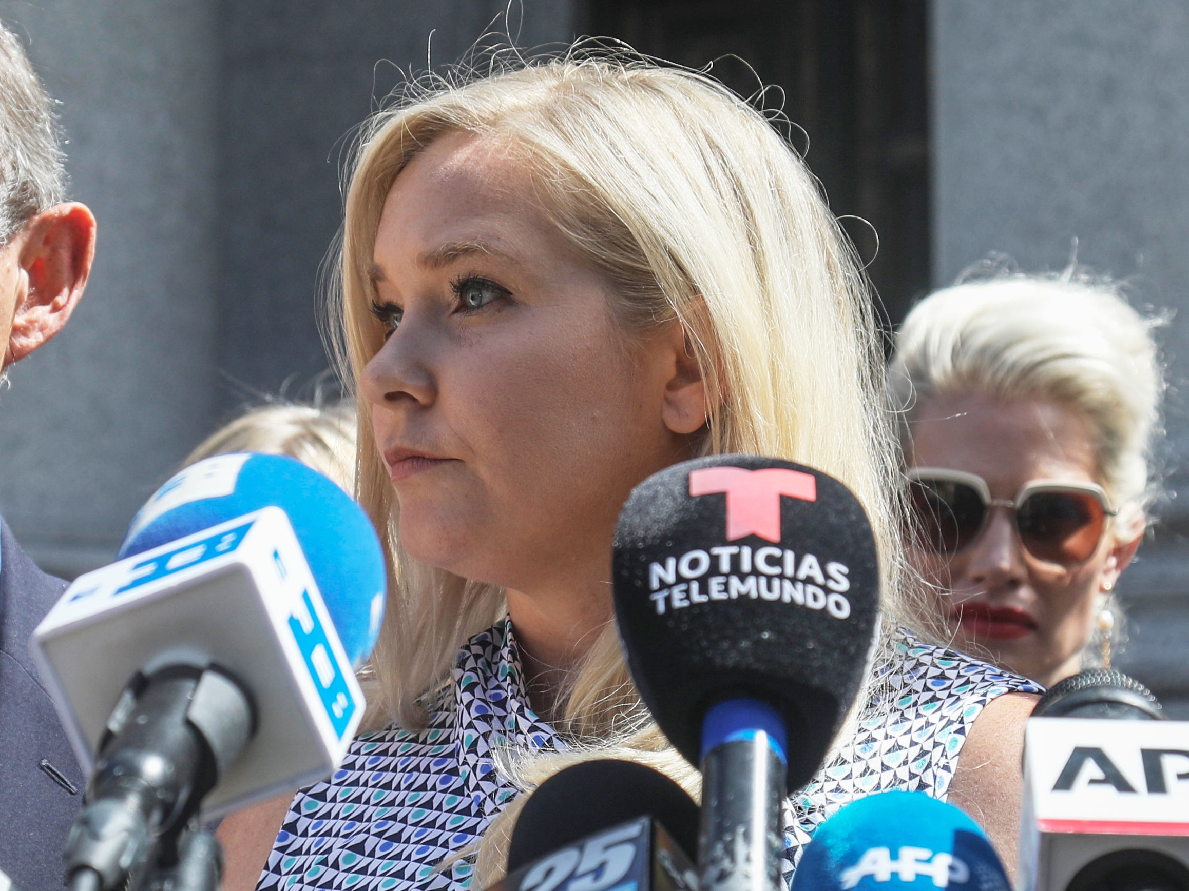caption: Virginia Giuffre, center, holds a news conference outside a Manhattan court in New York, Aug. 27, 2019.