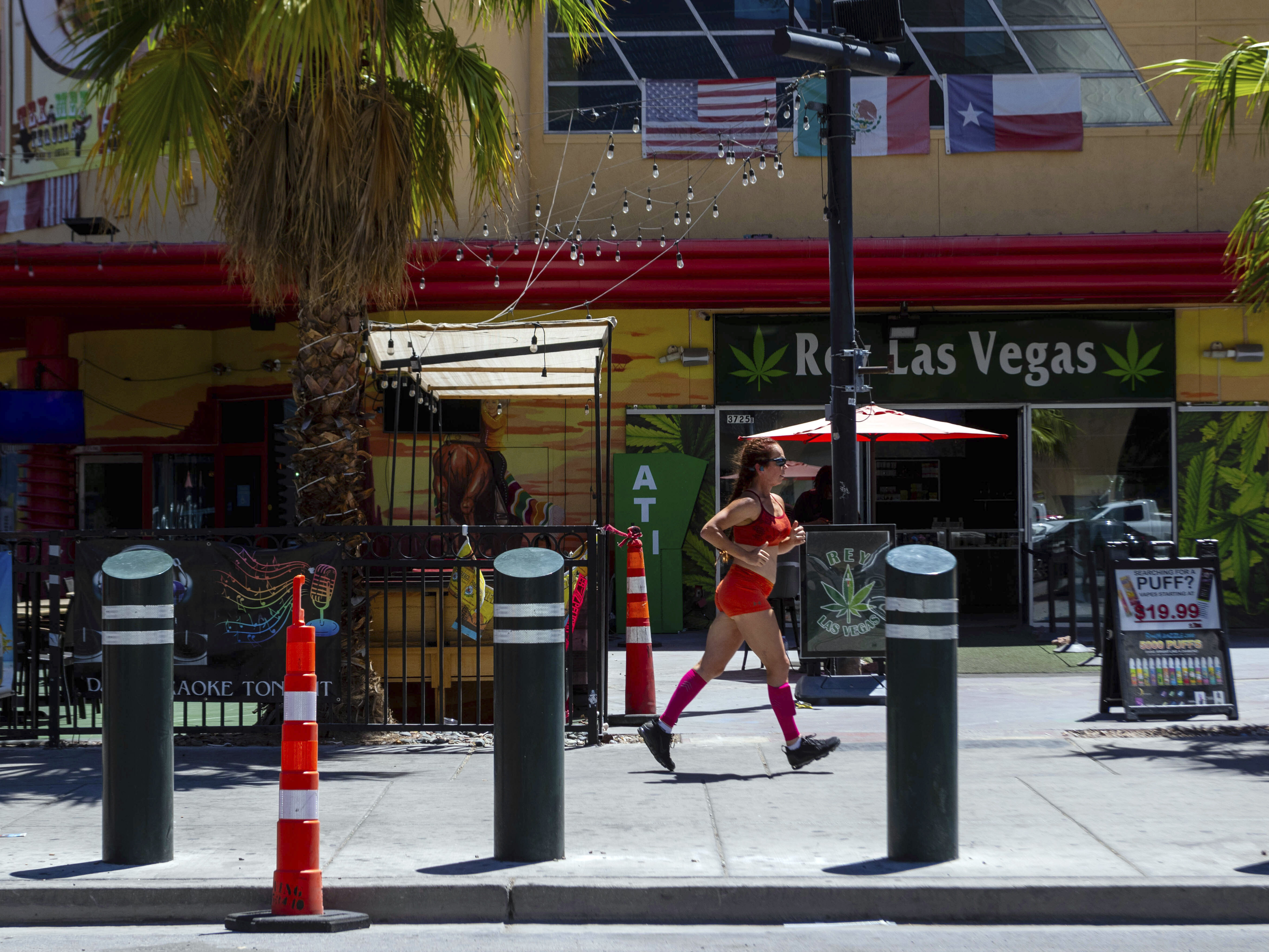 caption: A person jogs on the Las Vegas Strip during a heat advisory on Friday.