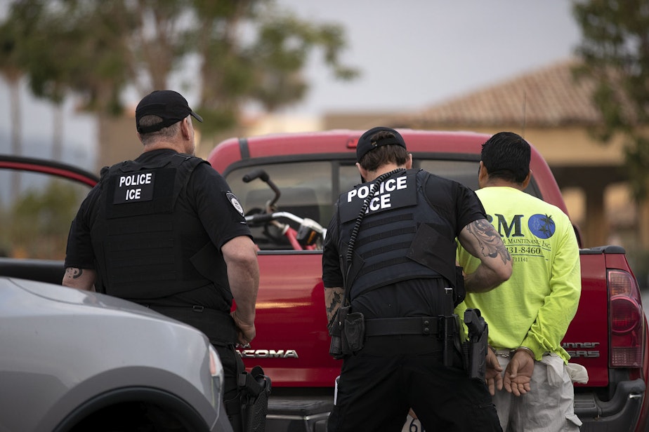 caption: In this July 8, 2019, photo, a U.S. Immigration and Customs Enforcement (ICE) officers detain a man during an operation in Escondido, Calif. (Gregory Bull/AP)