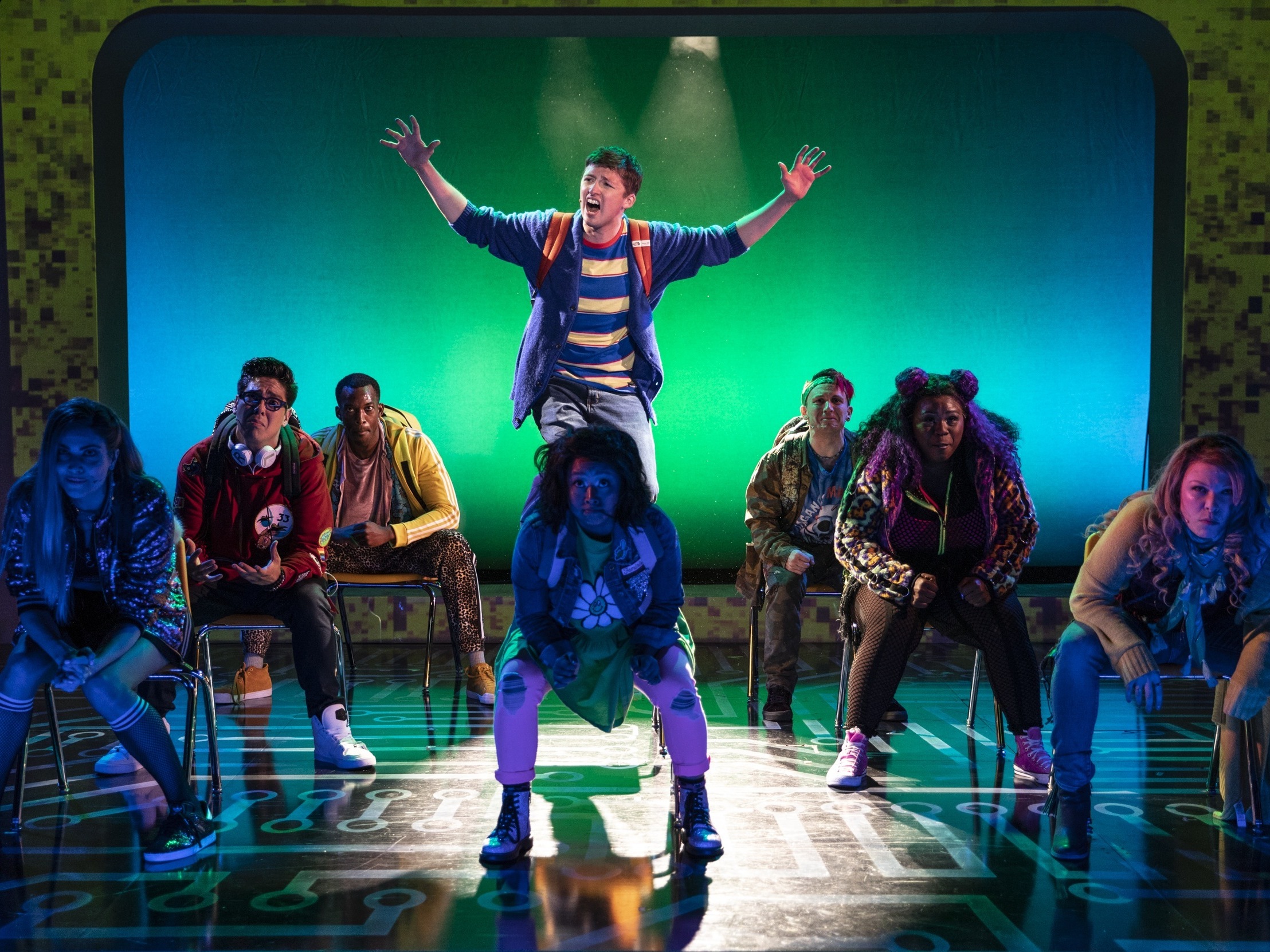 caption: In the current production of <em>Be More Chill</em>, an unpopular high school student named Jeremy (played by Will Roland, center) swallows a pill (which is actually a microcomputer) in order to be more, well, chill. The show moves to Broadway in early 2019.