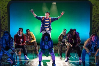 caption: In the current production of <em>Be More Chill</em>, an unpopular high school student named Jeremy (played by Will Roland, center) swallows a pill (which is actually a microcomputer) in order to be more, well, chill. The show moves to Broadway in early 2019.