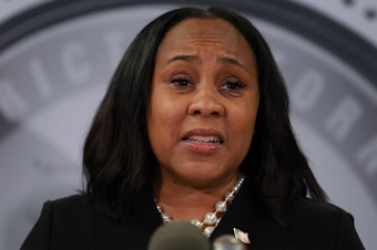 caption: Fulton County District Attorney Fani Willis speaks during a news conference in Atlanta on Aug. 14.