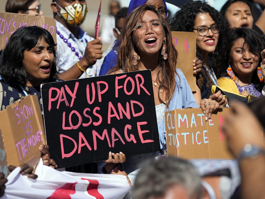 caption: Climate activists at the United Nations climate conference in Egypt call for money to pay for loss and damage from global warming in low-income countries.