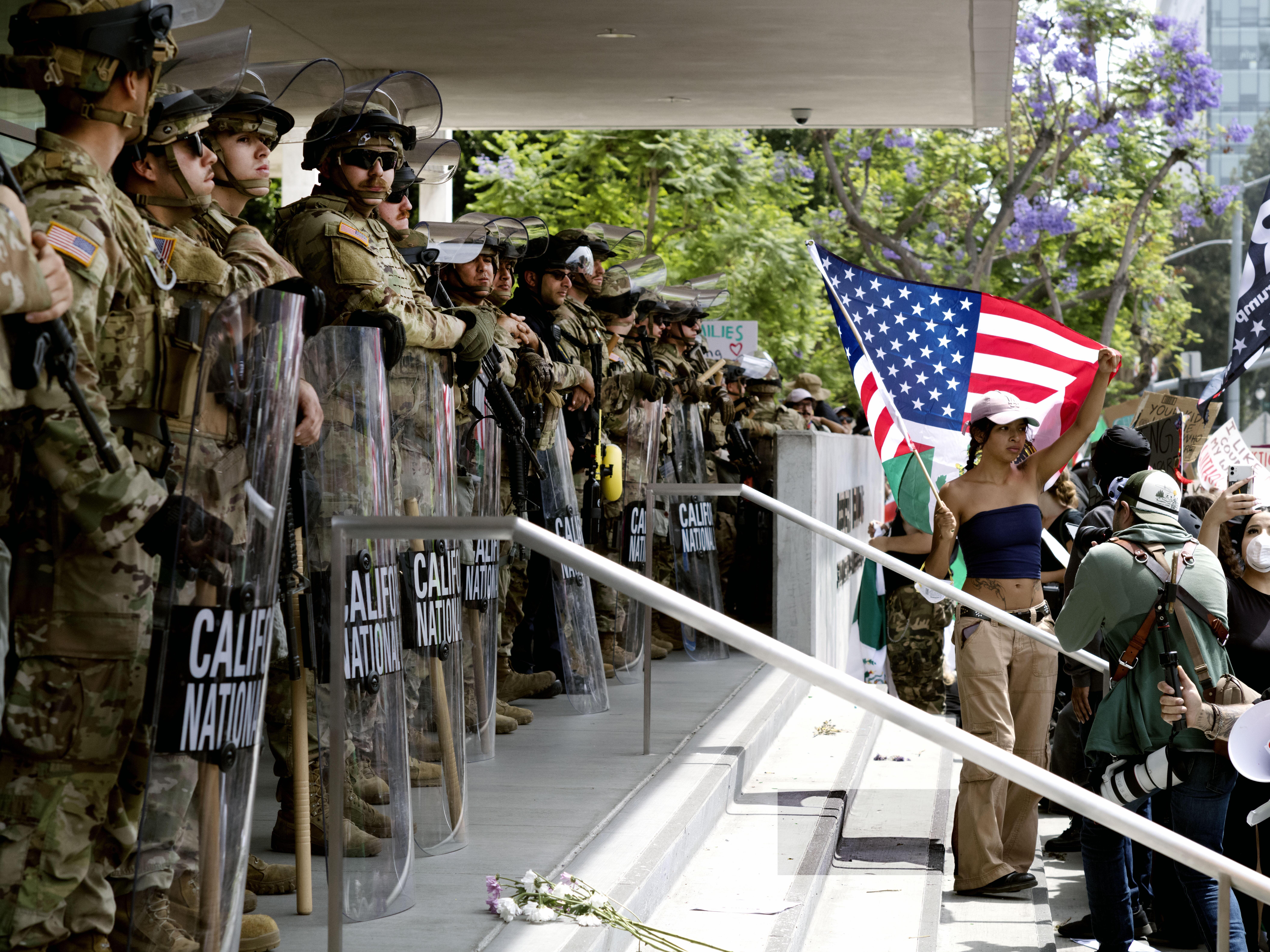 caption: Protesters stand off against California National Guard soldiers at the Federal Building in downtown Los Angeles during a "No Kings" protest on Saturday.