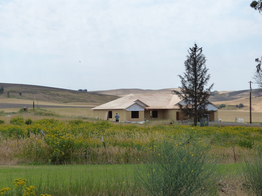 caption: A new home is built up in Pine City, WA after a wildfire.