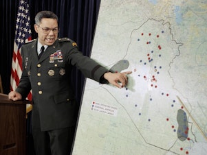 caption: Chairman of the Joint Chiefs of Staff Colin Powell points to Iraqi airbases at a Pentagon briefing on Jan. 23, 1991. Powell became a household name during the first Gulf War.