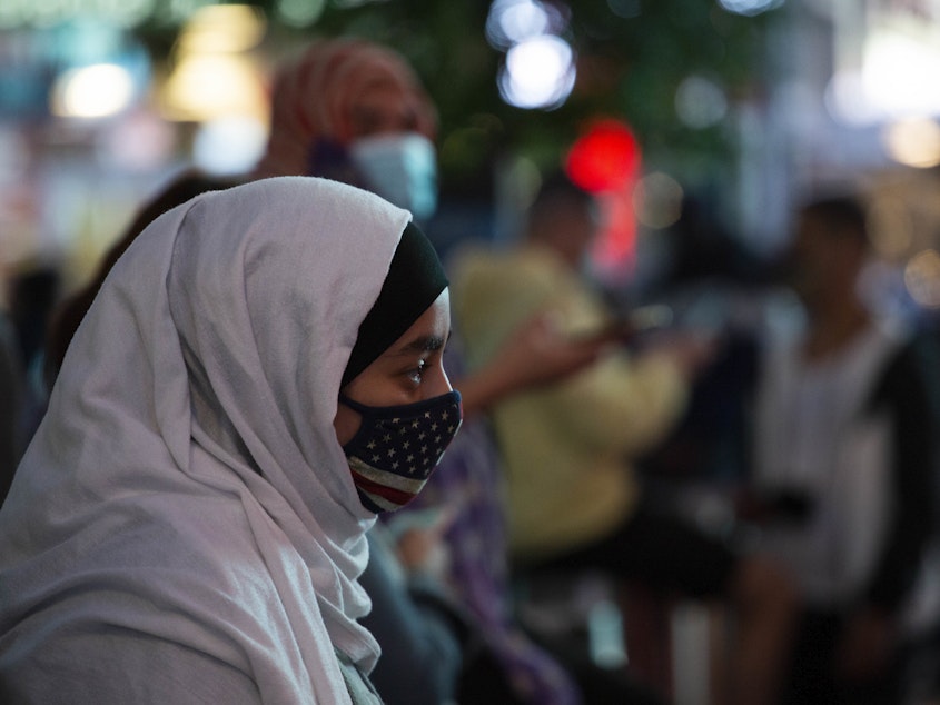 caption: A woman wears a hijab and an American flag mask during an Election Day celebration at Times Square on Saturday, Nov. 2020 in New York, NY. Joe Biden received a record-breaking 75 million votes during the 2020 Presidential Election against Donald Trump.