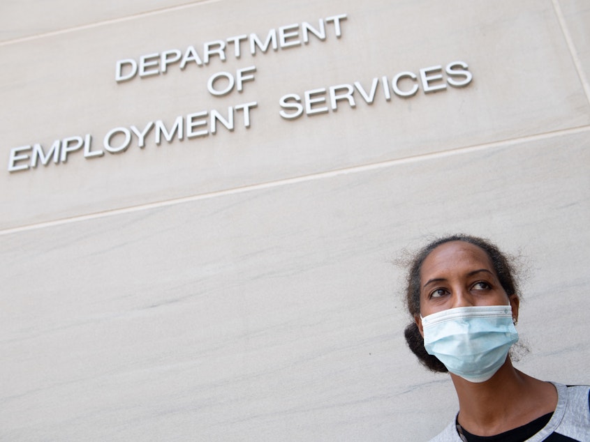 caption: Diana Yitbarek seeks information about her unemployment claim in Washington, D.C., on July 16. Applications for jobless benefits nationwide have been dropping but remain very high by historical standards.
