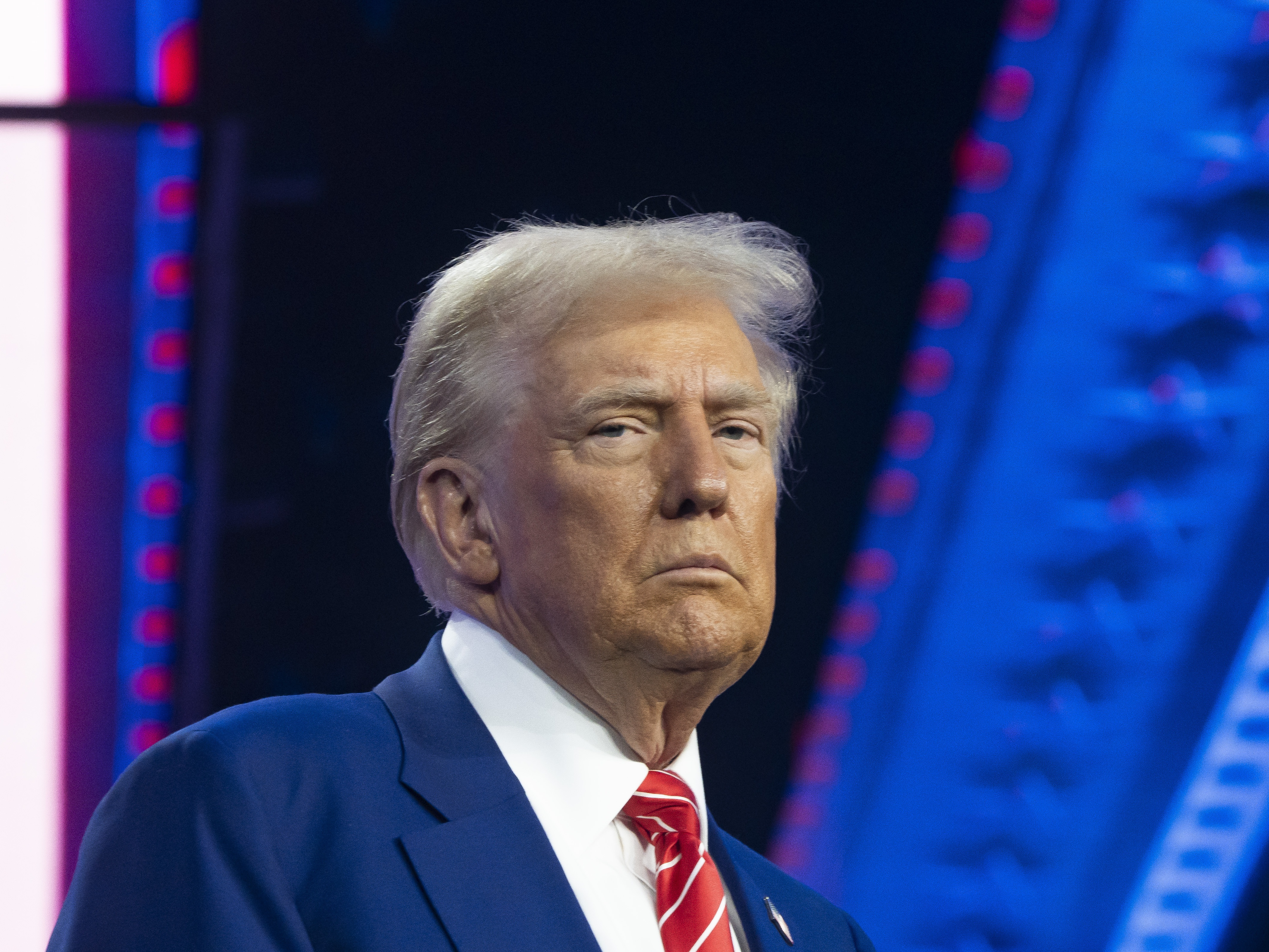 caption: U.S. President-elect Donald Trump looks on during Turning Point USA's AmericaFest at the Phoenix Convention Center on Dec. 22, 2024, in Phoenix. The annual four day conference geared toward energizing and connecting conservative youth hosts some of the country's leading conservative politicians and activists.