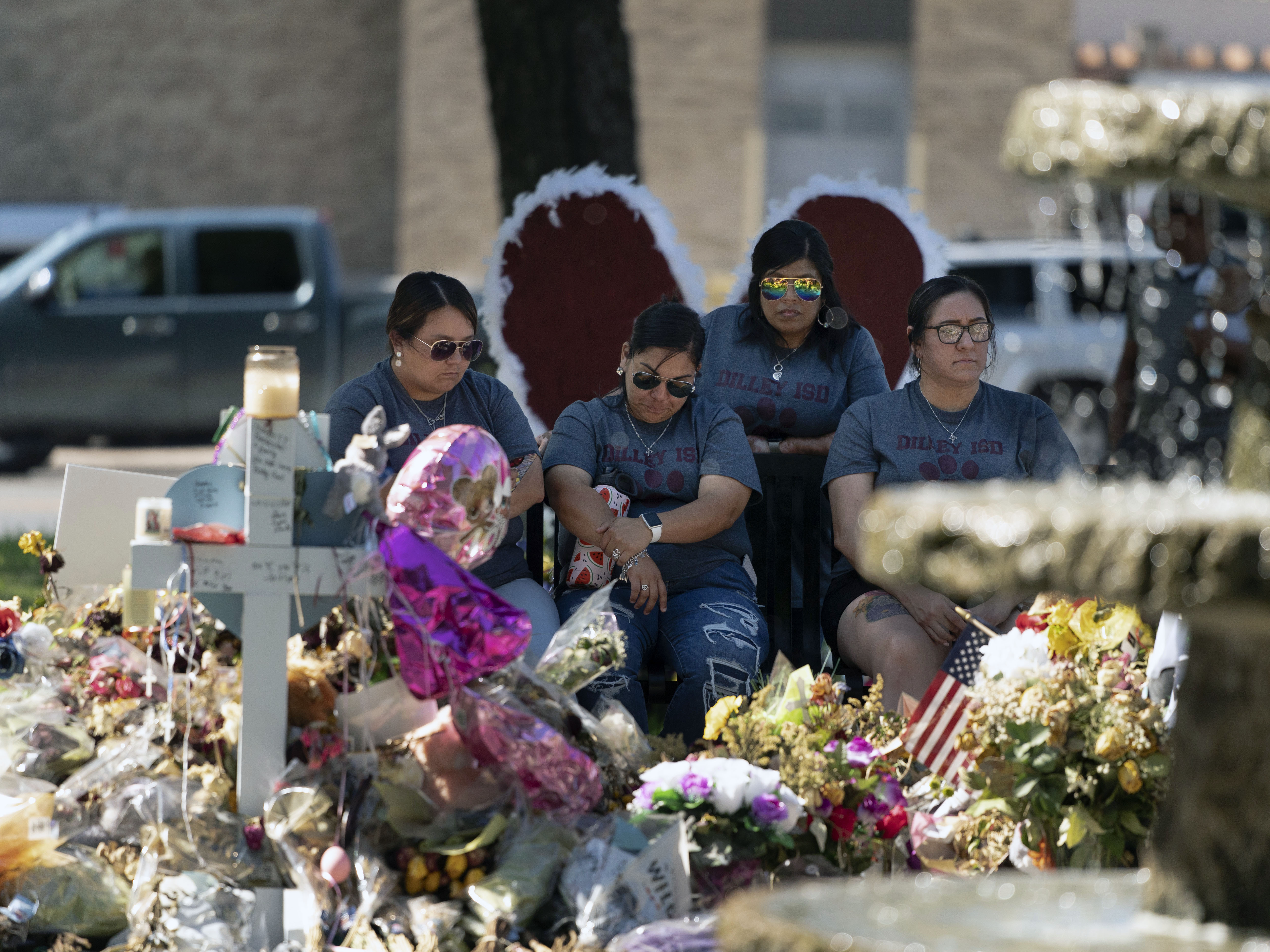 caption: A group of teachers visiting from Dilley, Texas, view a memorial honoring the victims killed in last week's elementary school shooting in Uvalde, Texas, Friday, June 3, 2022.