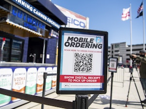 caption: A mobile ordering sign is seen on March 30 at a vending station in Nationals Park, home of the Washington Nationals. The Nats, along with many other teams in baseball, are implementing new safety protocols, including for ordering food, as a new season kicks off on Thursday.