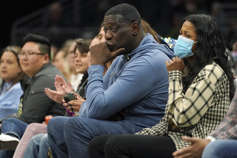 caption: Former Seattle SuperSonics forward Shawn Kemp, center, attends a WNBA basketball game between the Seattle Storm and the Chicago Sky, Wednesday, May 18, 2022 in Seattle