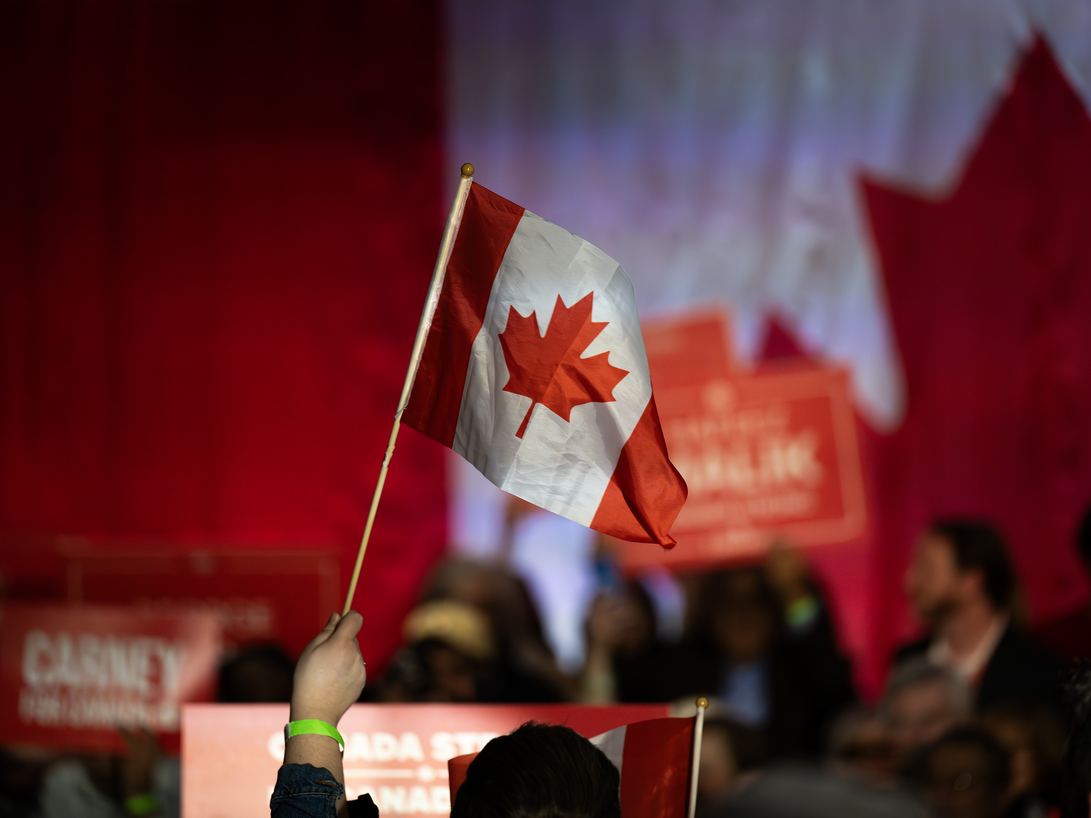 caption: A supporter waves a Canadian flag during a campaign rally for Mark Carney, Canada's prime minister, in Calgary, Alberta, Canada, on Tuesday, April 8, 2025. Carney said Donald Trump's tariff policy is an act of economic self-sabotage that's pushing the US into a downturn. Photographer: Gavin John/Bloomberg via Getty Images