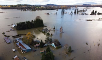 caption: Homes are shown surrounded by flood waters on Tuesday, November 16, 2021, east of Mount Vernon. 