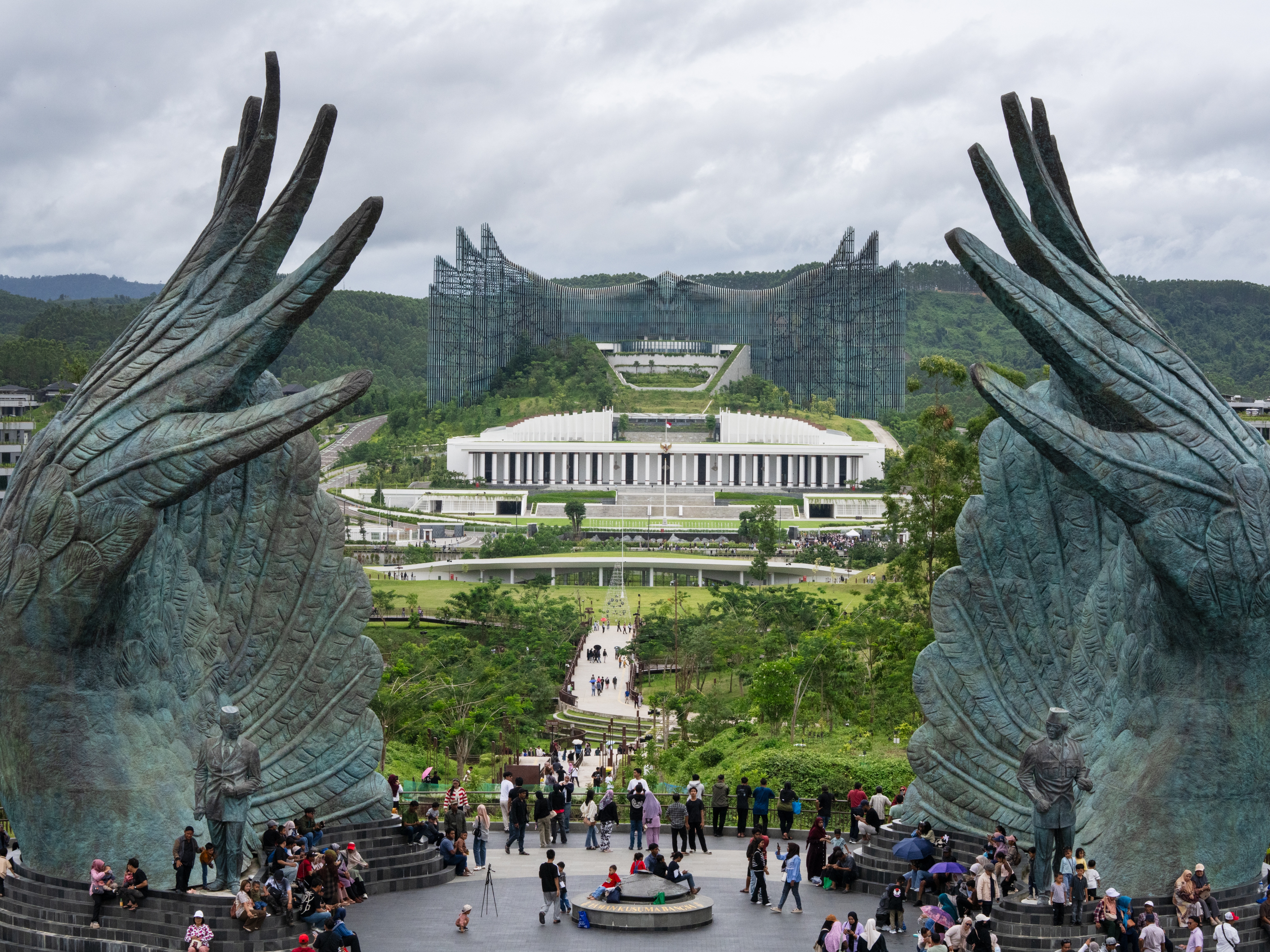 caption: People walk around Nusantara, where Indonesia aims to move its capital. Jakarta, the current capital and the world's largest city, is sinking.