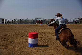 caption: A barrel race at the Denver Gay Rodeo in 2021.