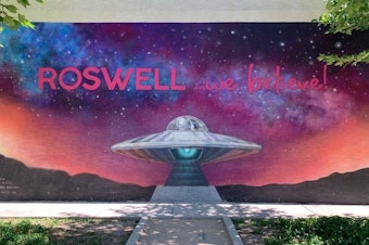 caption: A mural in Roswell, N.M., displays the town slogan. A mysterious aircraft crash in 1947 led to the local legend of visitors from another planet.