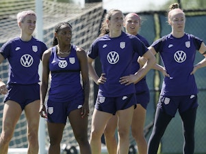 caption: U.S. national team player Crystal Dunn, second from left, listens to instructions with teammates during practice for a match against Nigeria Tuesday, Aug. 30, 2022, in Riverside, Mo.