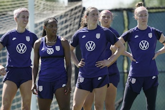 caption: U.S. national team player Crystal Dunn, second from left, listens to instructions with teammates during practice for a match against Nigeria Tuesday, Aug. 30, 2022, in Riverside, Mo.