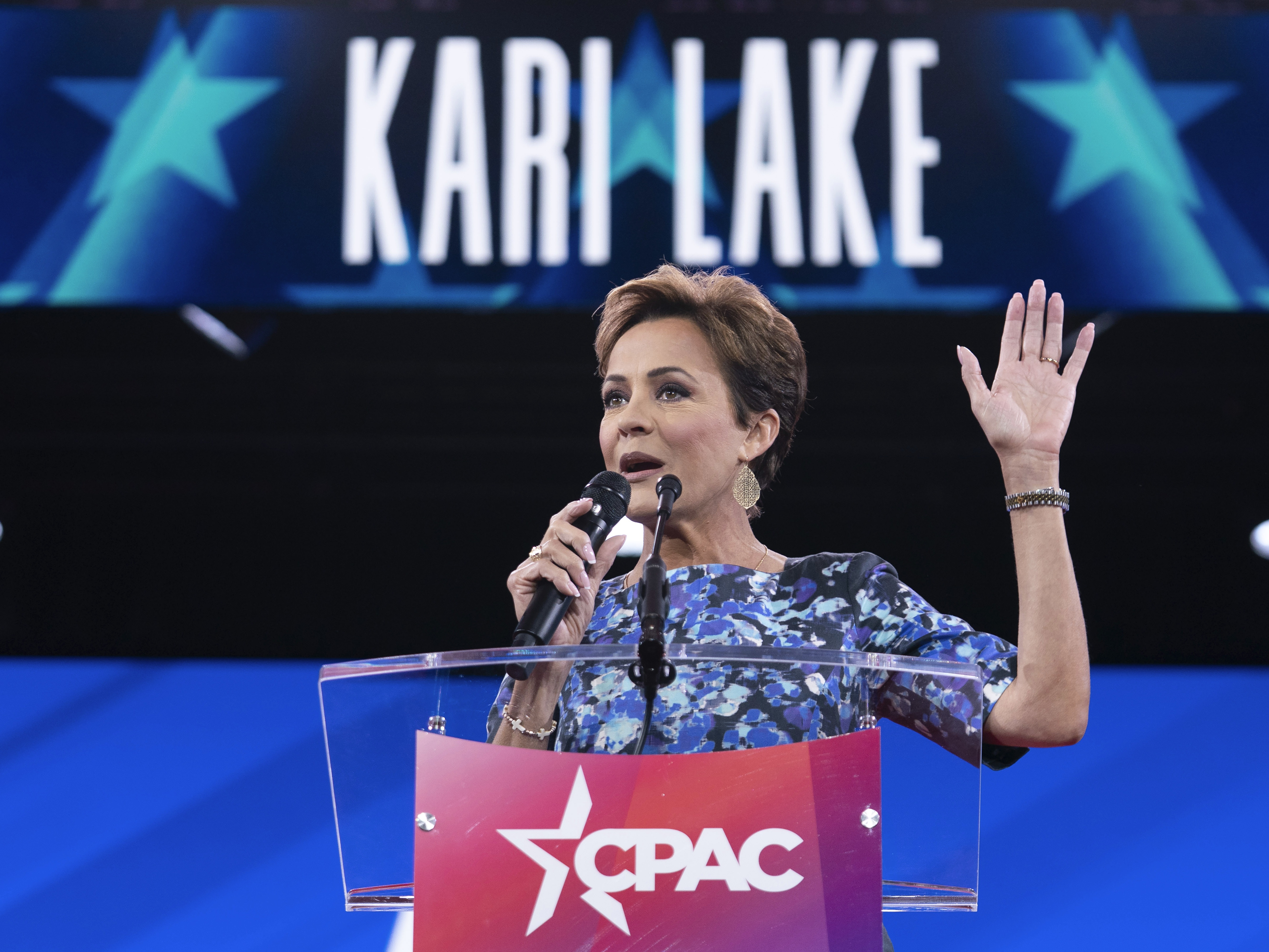 caption: Senior Trump adviser Kari Lake, shown above at a conservative conference earlier this year, announced Tuesday night that Voice of America would rely on coverage from the far-right television network OAN. Voice of America employees that Lake put on indefinite leave are suing to be restored to their jobs.