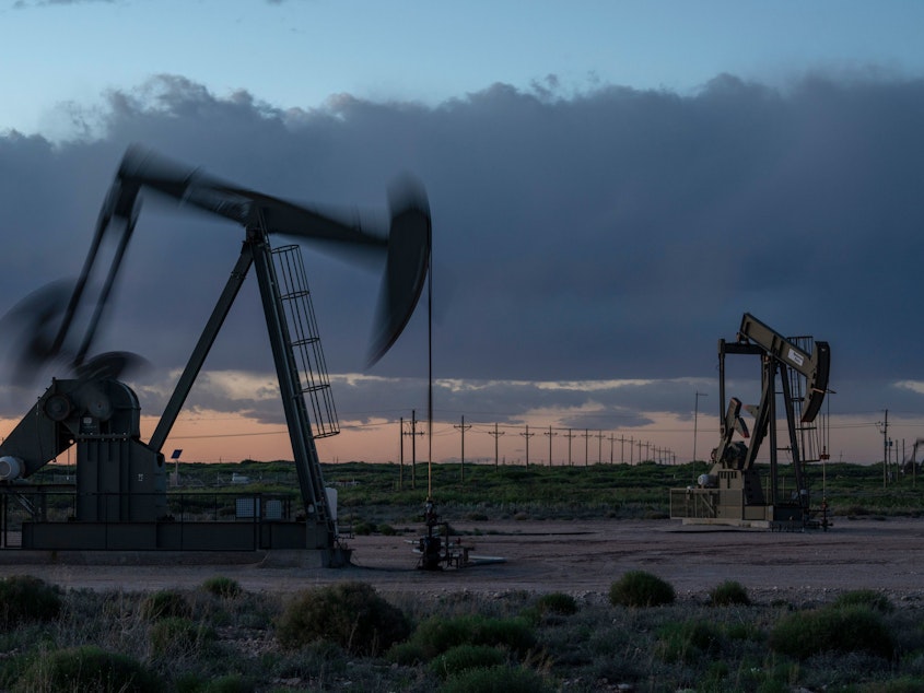 caption: Pump jacks operate at dusk near Loco Hills in Eddy County, New Mexico, on April 23. U.S. oil producers are grappling with prolonged low oil prices and the uncertainty created by the coronavirus pandemic.