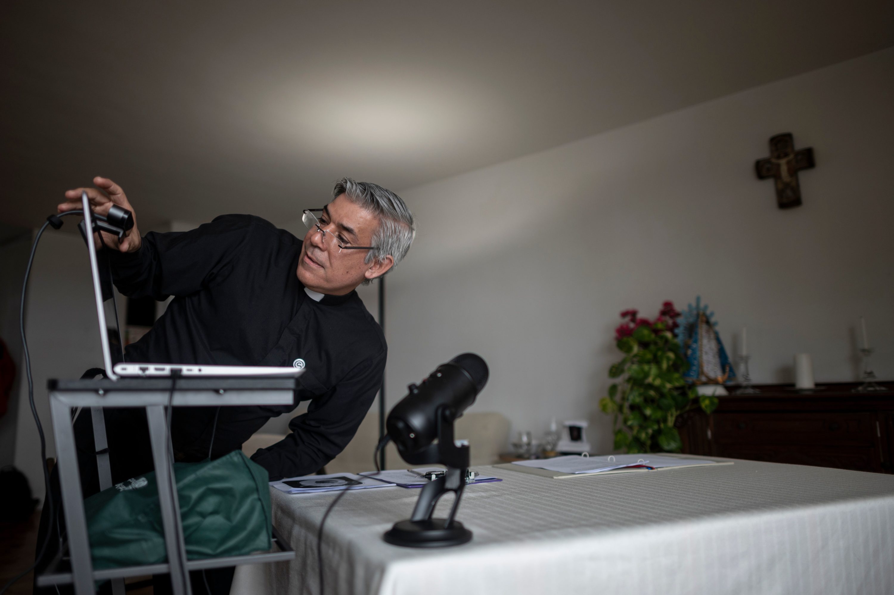 caption: Fabian Arias, a Lutheran pastor with Saint Peter's Church in Manhattan, prepares his Sunday services via internet live stream on May 24, 2020 in the streets in Harlem neighbourhood of Manhattan in New York. (JOHANNES EISELE/AFP via Getty Images)