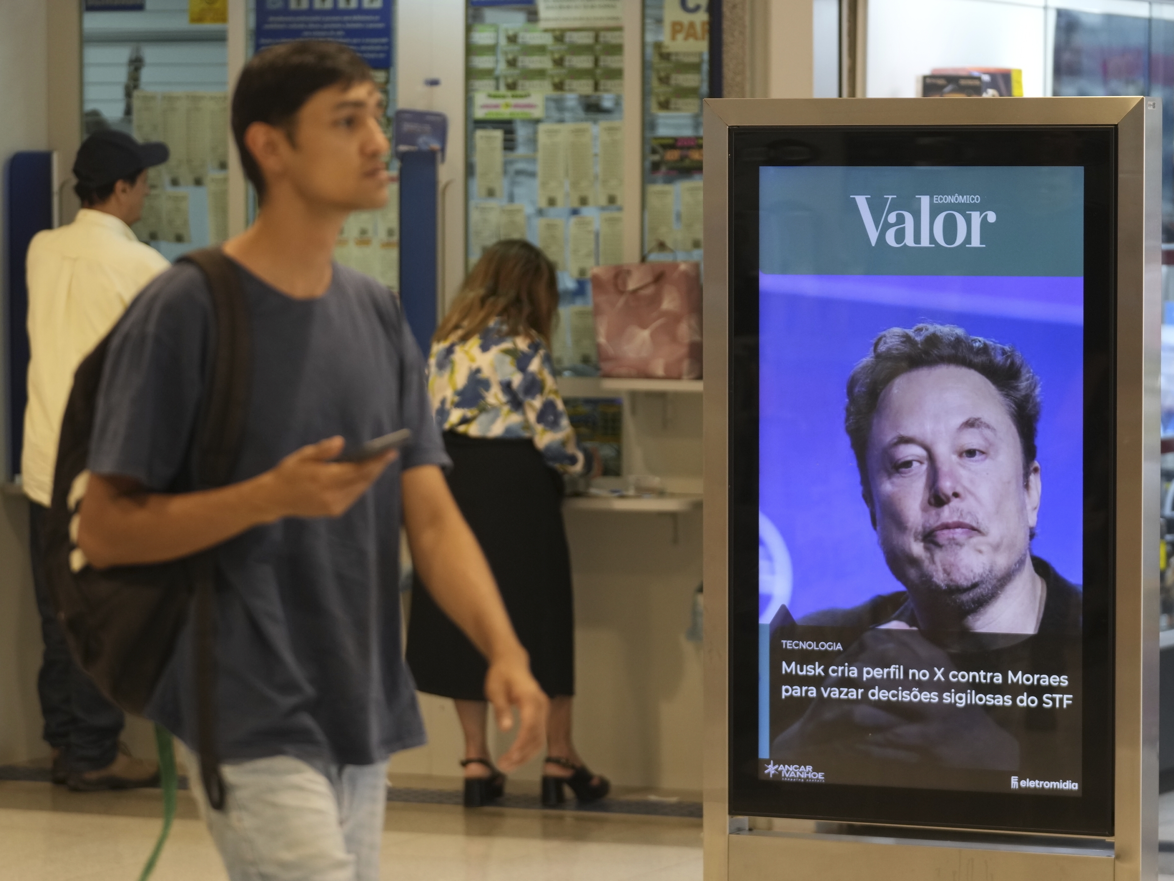 caption: An ad by Valor media shows a photo of Elon Musk at a shopping center in Brasilia, Brazil, on Sept. 2.