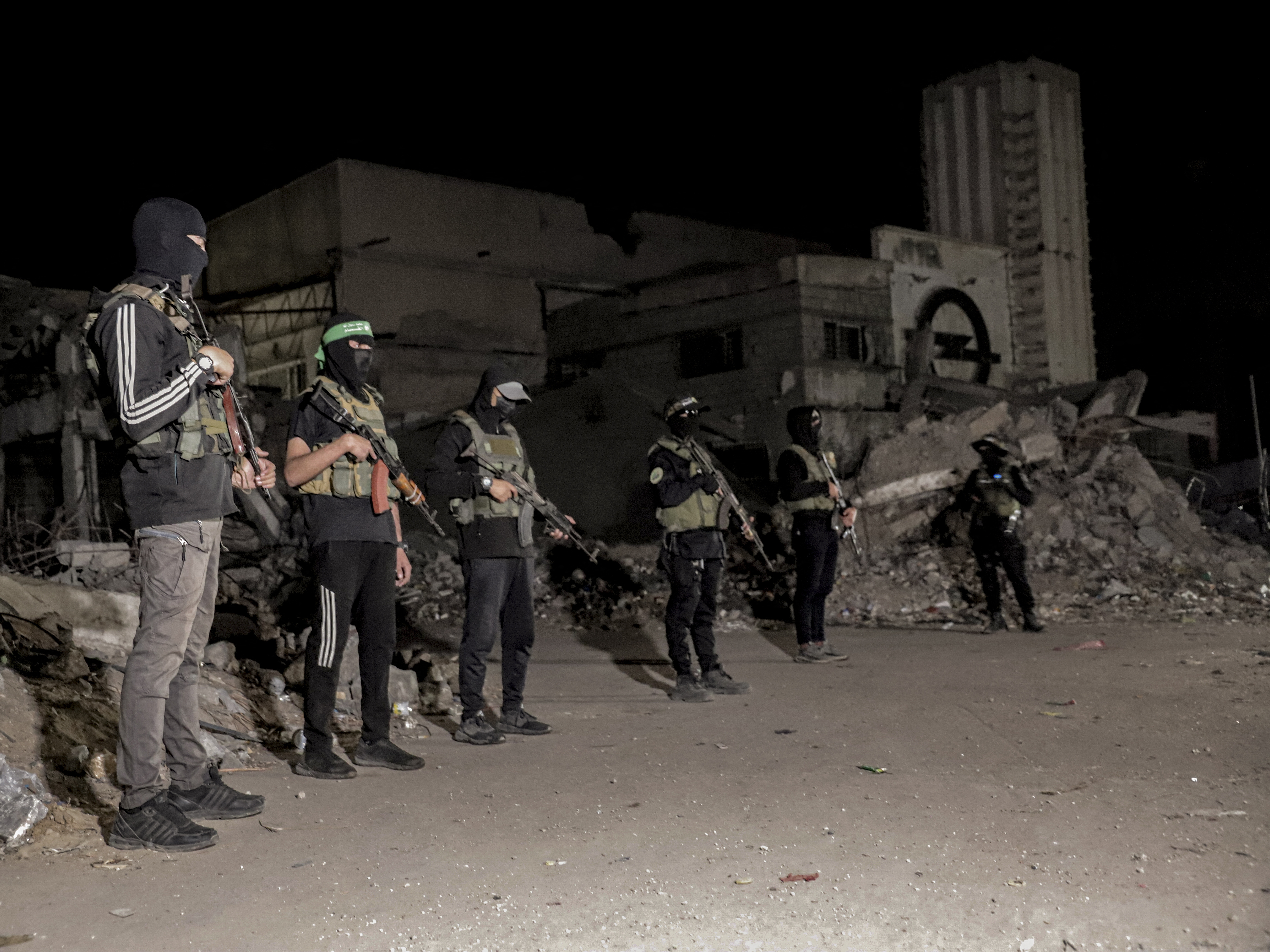 caption: Hamas militants stand guard in Gaza on Wednesday. Hamas police and other armed Hamas members have returned to the streets of Gaza since a ceasefire was announced last week. The plan calls for Hamas to disarm and for newly trained police to take over in Gaza, but it's not clear when that might happen.