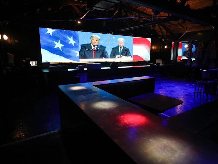 caption: Former President Donald Trump and now-President Biden, as seen on television during the Oct. 22, 2020 presidential debate. Their first debate this year airs on Thursday on CNN.