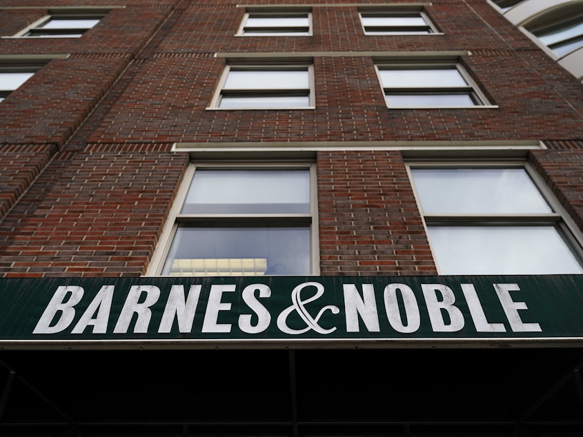 caption: The sign for a Barnes & Noble bookstore hangs above the entrance to one of its locations in Brooklyn earlier this year. The book retailer and Elliott Management Corp. announced Friday that they have agreed to a sale price of about $683 million.