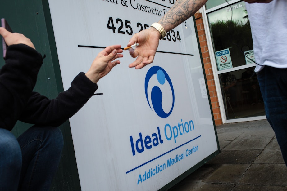 caption: Patients share a cigarette outside the Everett Ideal Option clinic, an addiction treatment center. (Finding Fixes)