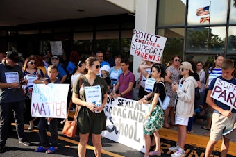 caption: Supporters of Florida's recently signed Parental Rights in Education law demonstrate at the Duval County Public Schools building in Jacksonville, Fla., on May 3.