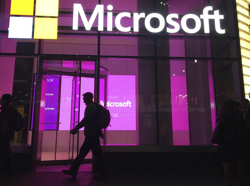 caption: FILE - In this Nov. 10, 2016, file photo, people walk near a Microsoft office in New York. Microsoft Corp. reports earnings, Thursday, April 27, 2017. 