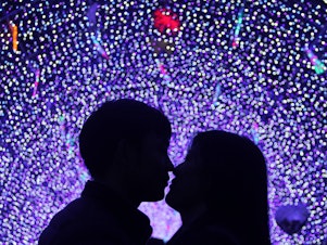 caption: A couple kiss at a lantern show to celebrate Valentine's Day on February 14, 2016 in Binzhou, China.