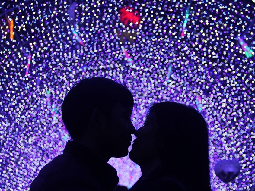 caption: A couple kiss at a lantern show to celebrate Valentine's Day on February 14, 2016 in Binzhou, China.
