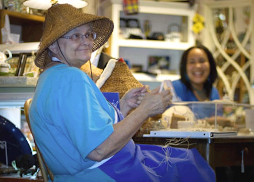 caption: Artist Lois Thadei in woven hat, photographed at Ginger Street in Olympia during Art Walk. 