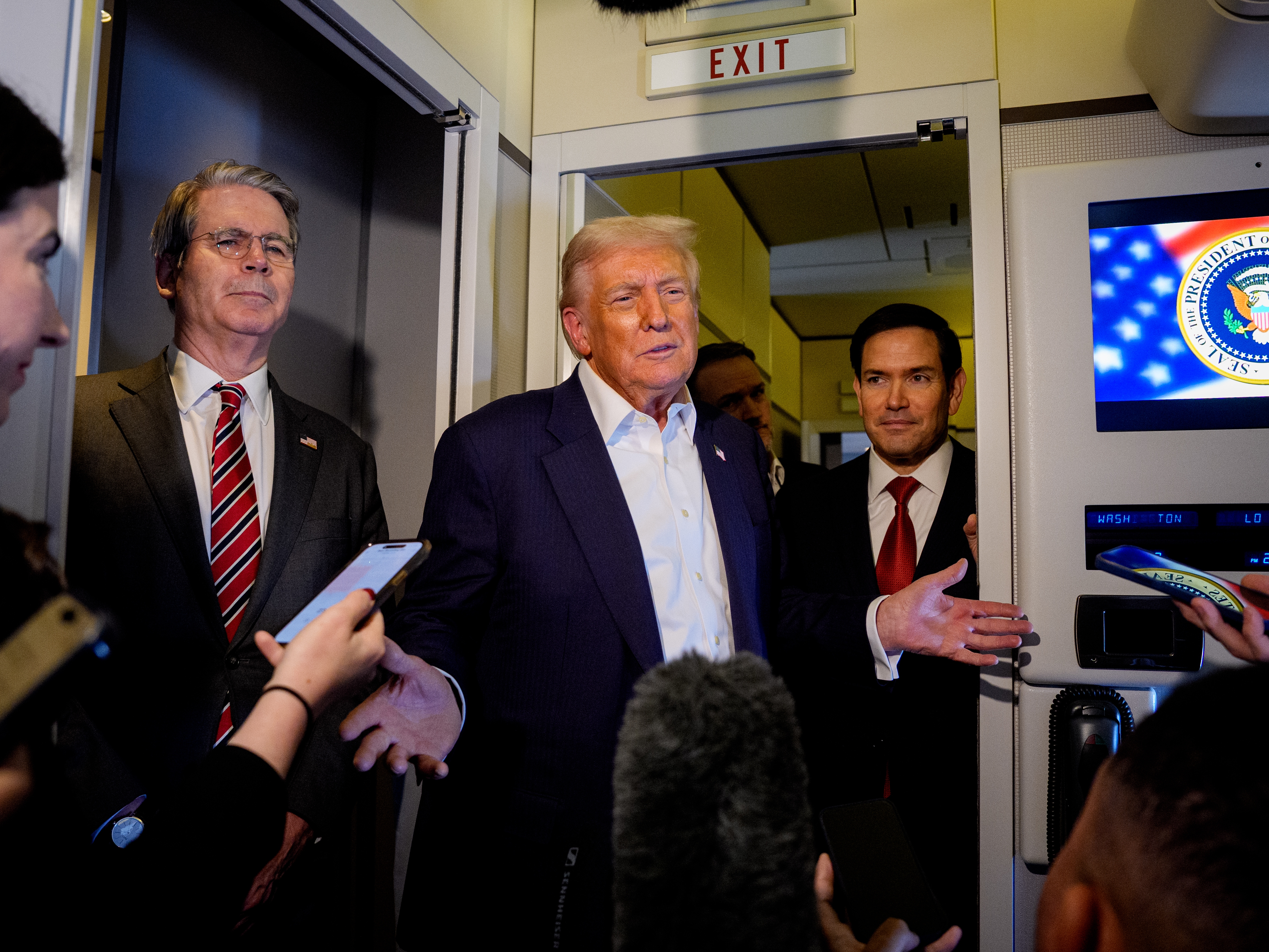 caption: President Trump talks to reporters on Air Force One with Treasury Secretary Scott Bessent (left) and Secretary of State Marco Rubio on Monday.