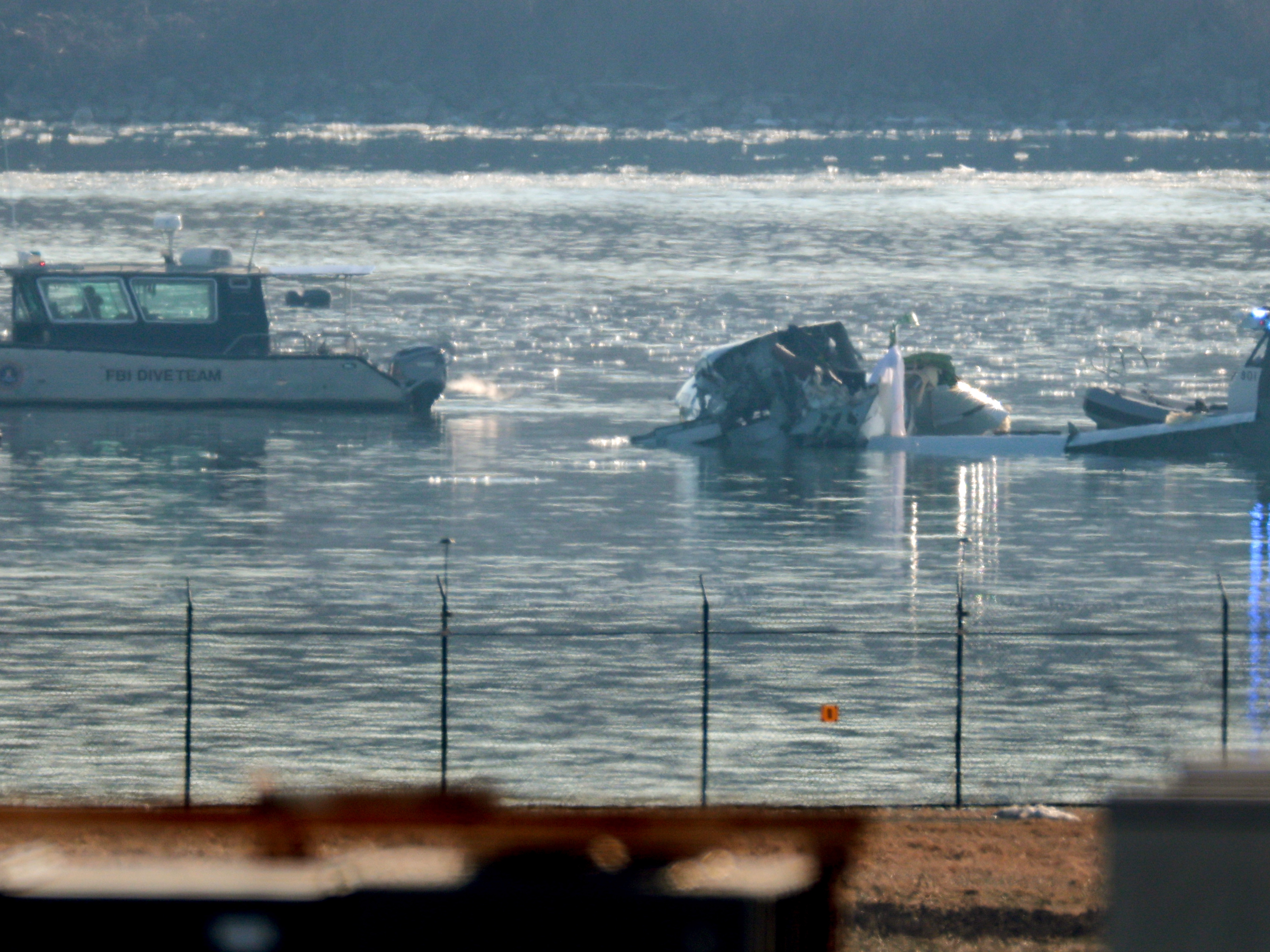 caption: Emergency response units search the crash site of an American Airlines plane on the Potomac River after a crash while on approach to Reagan National Airport on Jan. 30, 2025 in Arlington, Va. The American Airlines flight from Wichita, Kan., collided midair with a military Black Hawk helicopter.