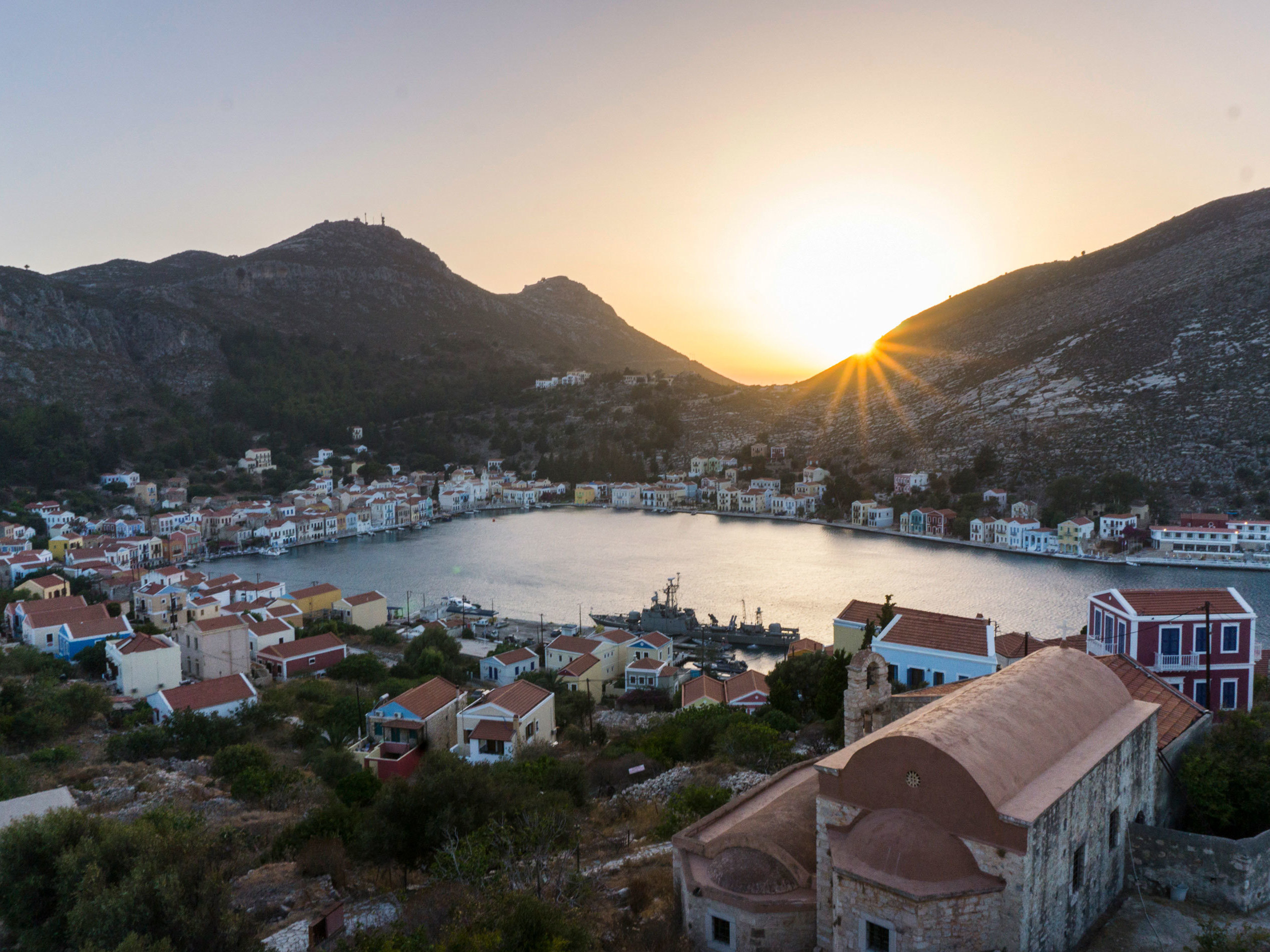 caption: The Greek island of Kastellorizo, shown here at sunset from the top of an ancient castle, is a little over a mile away from the Turkish shore. Known for its architecture, turquoise sea and friendship with the neighbor Turks, it's recently become a pawn in a geopolitical dispute between the Greek and Turkish governments over hydrocarbons and maritime borders.