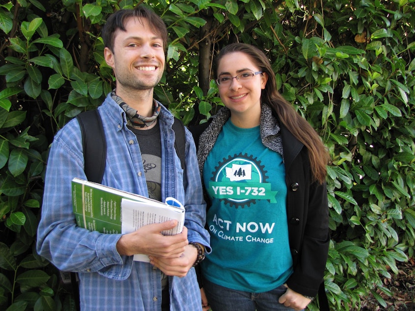 caption: Ben Silesky, 26, and Sydney Allen, 21, go door to door to raise awareness and support for ballot Initiative 732, which would put a tax on carbon emissions in Washington. 
